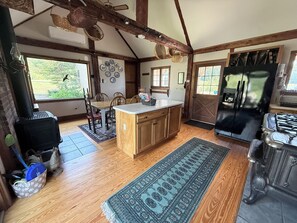 A spacious kitchen with wooden cabinets, a central island, and a large refrigerator.