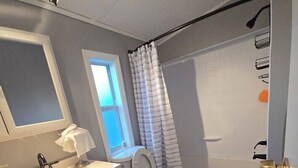 Une salle de bain équipée de toilettes, d’un lavabo et d’une douche.