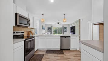 Een broodrooster, kookgerei, borden en bestek, kruiden, een eettafel