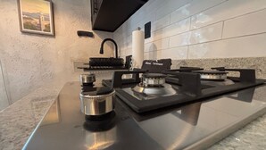 A kitchen with a stainless steel stove, a black faucet, and a framed picture on the wall. - Casa Turicum Val'Quirico Centro (Val'Quirico)