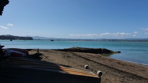 Ein Strand mit Booten und blauem Himmel.
