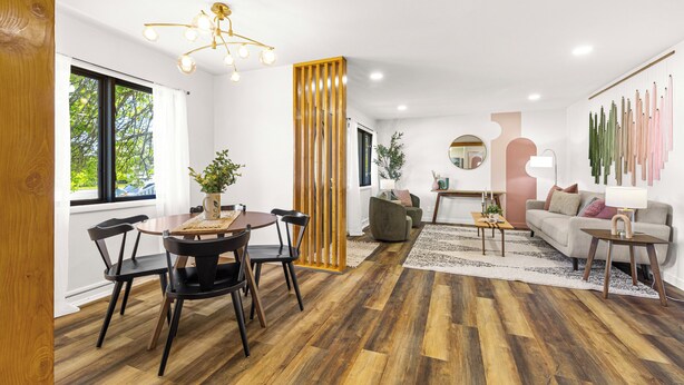 A modern living room with a wooden dining table, black chairs, a sofa, and a coffee table.