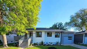 A single-story house with a front porch, a visible garage, and a well-maintained lawn.