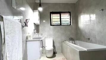 Een douche, handdoeken, zeep, toiletpapier