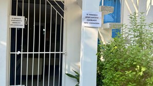 Une entrée fermée par un portail mène à un immeuble sur lequel est apposée une plaque indiquant qu’il s’agit d’un immeuble d’habitation.