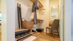 A modern bathroom with a wooden vanity, a chair, and a large woven basket. - Zcape X2 Condominium in Bang Tao (Choeng Thale)
