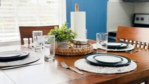 A dining table set with plates, glasses, and a centerpiece.
