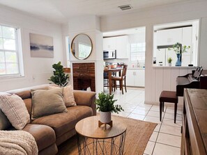 A living room with a brown sofa, a round coffee table, and a fireplace. There is a dining area with a table and chairs in the background. - Cozy home near MIA, Coral Gables & Brickell (Miami)