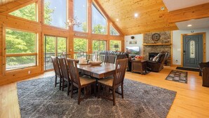 Amplia sala de estar con una mesa de comedor, sillas y una chimenea.
