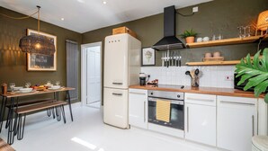 A modern kitchen with white cabinetry, a built-in oven, and a refrigerator. - Cozy Nook • Wood Burner • Terrace (London)