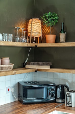 Een keuken met een magnetron, broodrooster en een hanglamp.