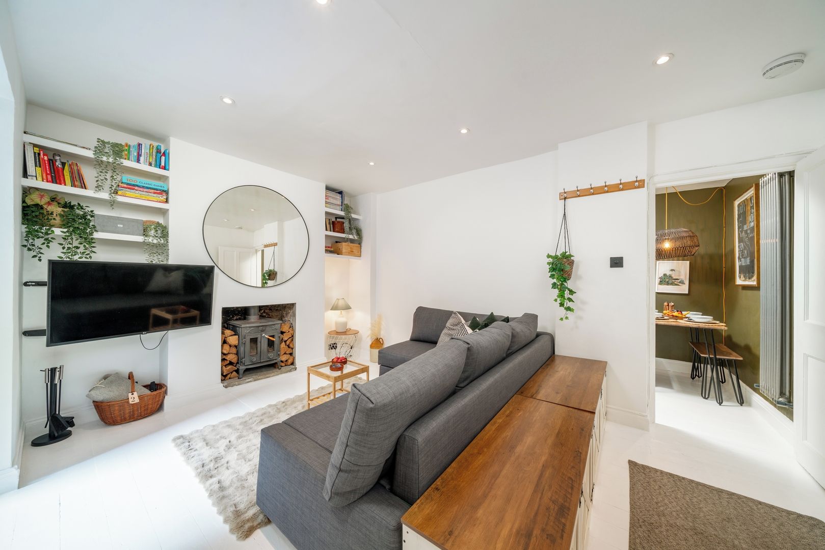 Una sala moderna con sofá, televisor de pantalla plana, chimenea y comedor.