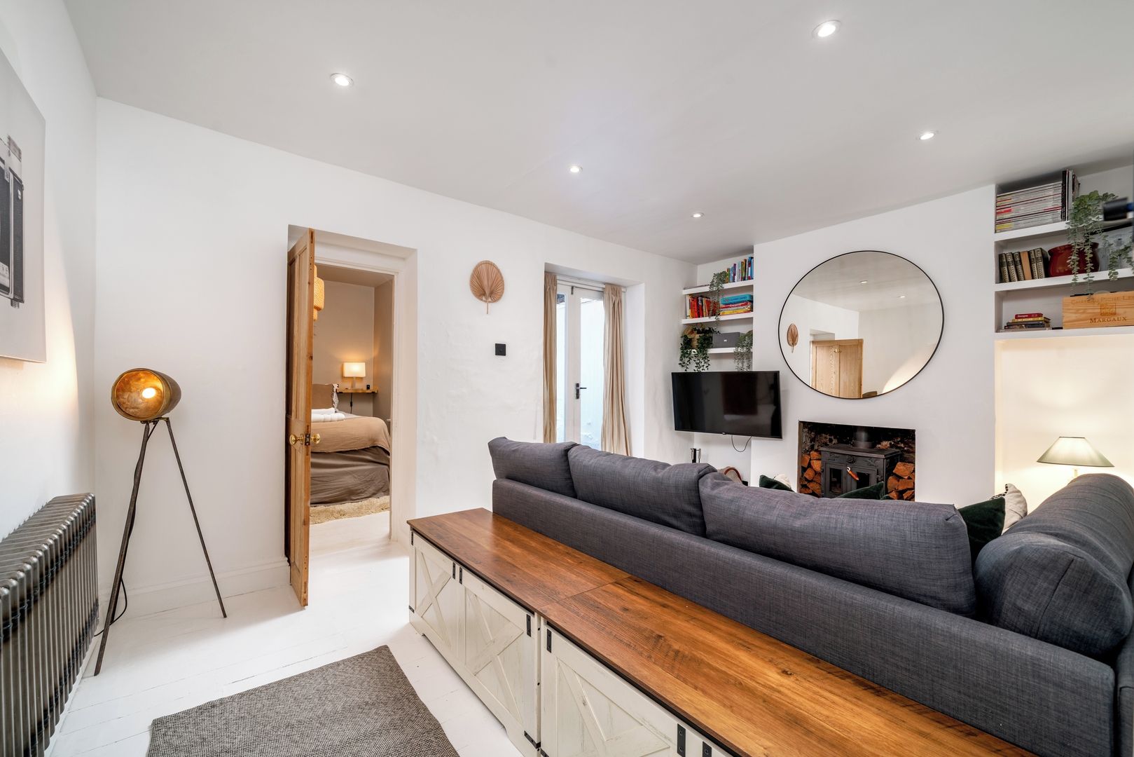 A modern living room with a sofa, a coffee table, a TV, and a fireplace.