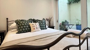 Une chambre à coucher avec un lit, une fenêtre et une vue sur un jardin.