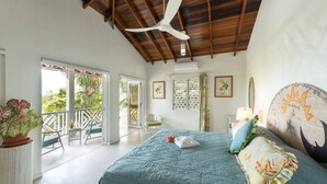 A bedroom with a bed, ceiling fan, and a view of the outdoors. - Villa Casabella | Ocean View - Located in  Fabulous Saint James with Private Pool (Saint James)