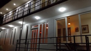 A two-story building with a balcony, multiple windows, and a staircase leading to the upper floor. - Hostal De María (San Cristóbal de las Casas)