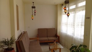 A living room with a sofa, a coffee table, and two hanging lamps. - Hostal De María (San Cristóbal de las Casas)