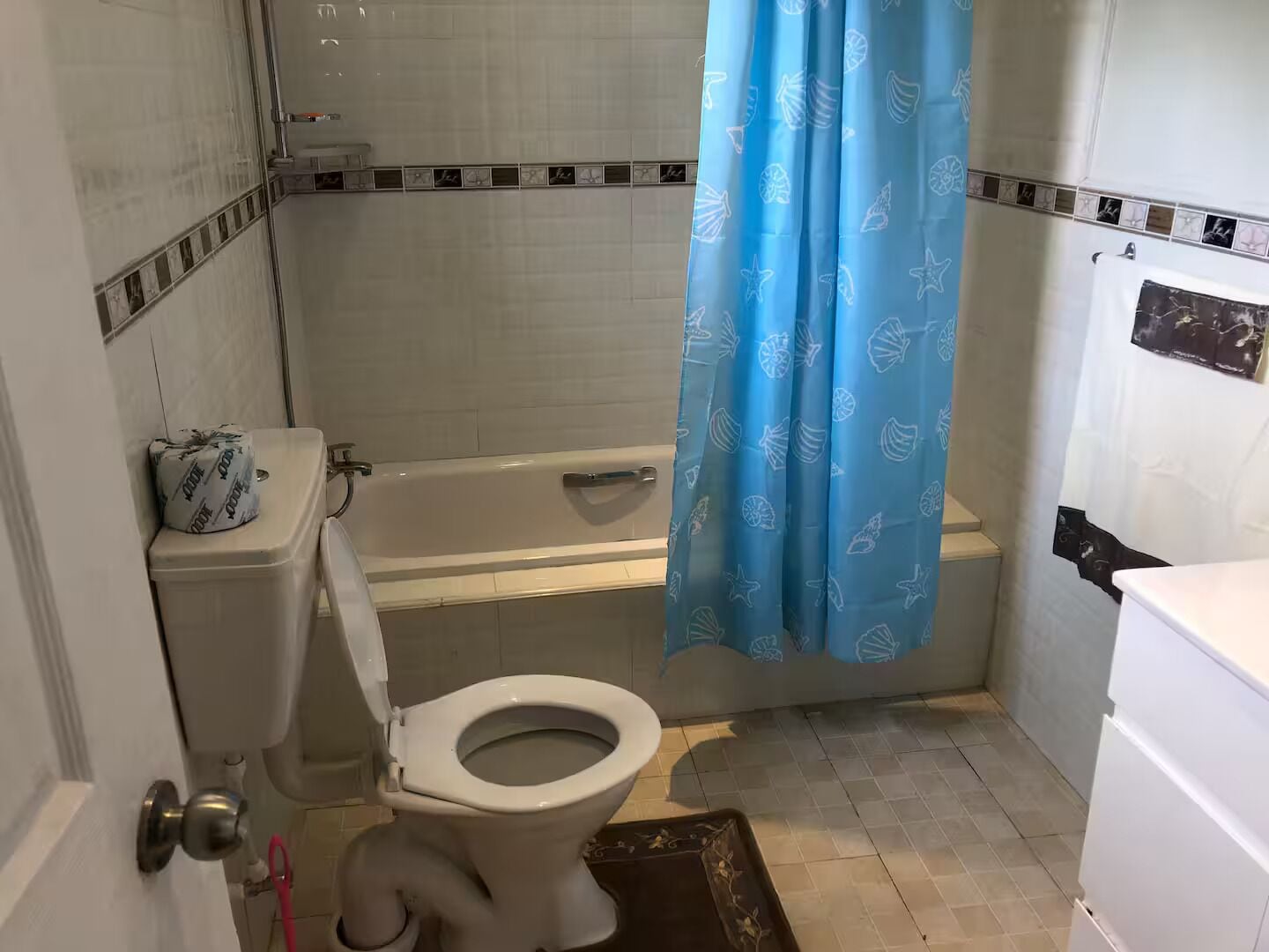 A bathroom with a toilet, bathtub, and shower curtain.