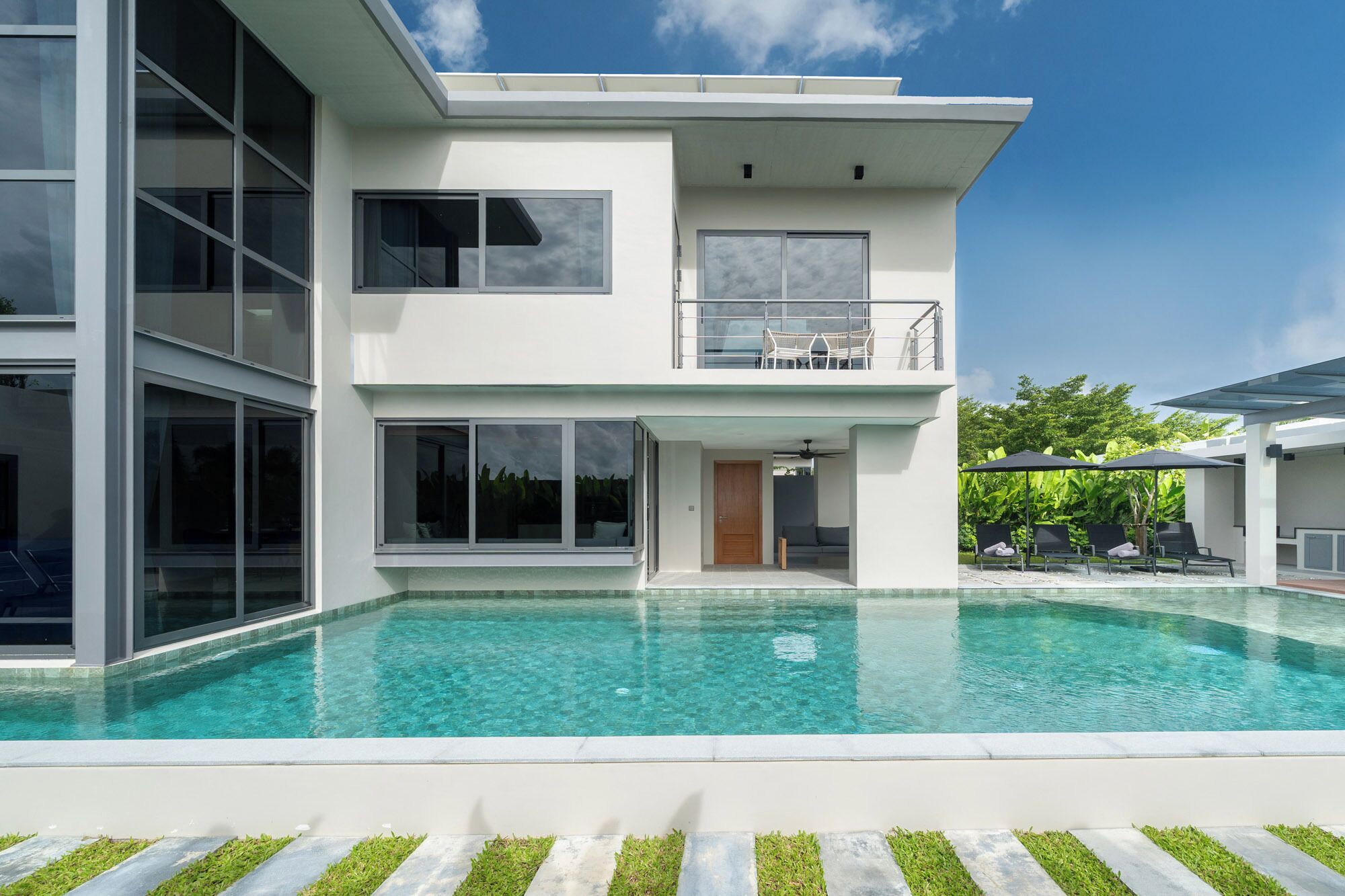 Una casa moderna de dos pisos con piscina delantera.