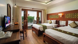 A hotel room with two beds, a desk with a TV, and a view of greenery outside. - De Arya Angkor Resort (Siem Reap)