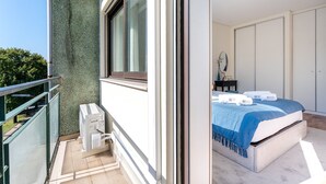 A balcony with a green wall, a window, and a small air conditioning unit. - GuestReady - Lovely Urban Retreat (Porto)