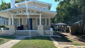 A two-story house with a covered porch, a front yard with a lawn and a patio area. - Fantastic apartment with AC in charming downtown Leesburg (Leesburg)