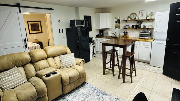 A compact living space with a sofa, a dining area, and a kitchenette. - Fantastic apartment with AC in charming downtown Leesburg (Leesburg)