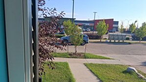 Un parking rempli de voitures, un bâtiment portant l’inscription « Hills Mart » et un restaurant appelé « Pizza House ».