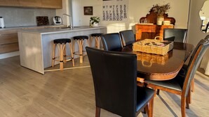 Une cuisine moderne dotée d’un îlot central, de tabourets de bar et d’une table à manger avec des chaises.