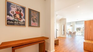 A spacious living area with a wooden bench, a dining table with chairs, and a view of the city through large windows. - GuestReady - Republic Apartments 8D (Lisbon)