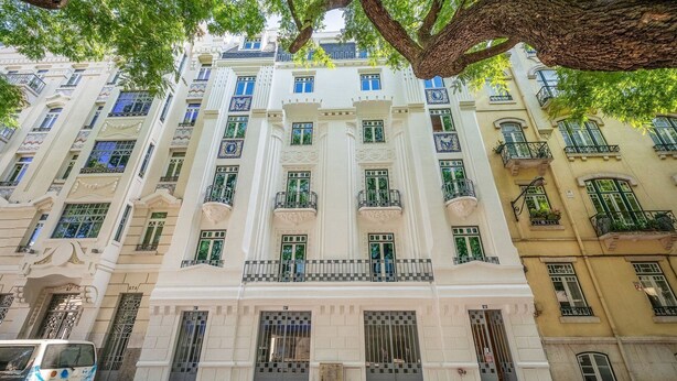 A multi-story building with a classical architectural style, featuring ornate balconies and large windows.