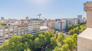 A cityscape with modern buildings, a river, and a construction crane. - GuestReady - Republic Apartments 8E (Lisbon)