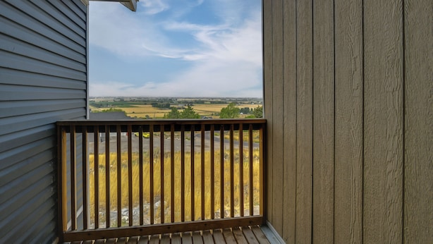 Ein Holzbalkon mit Blick auf eine ländliche Landschaft.
