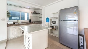 A modern kitchen with a stainless steel refrigerator, a built-in microwave, and a granite countertop. - 4BR PoolVilla and SeaView V199 (Patong)