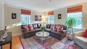 A cozy living room with a brown leather sofa, a round coffee table, and a patterned rug. - < 1 Mi to Dtwn Salem: Apt w/ Shared Patio & Yard! (Salem)