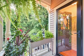Un balcon agrémenté de plantes en pot et offrant une vue sur un jardin luxuriant.