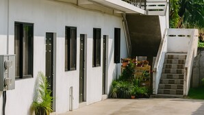 A modern building with a concrete exterior, multiple windows, and a staircase leading to an upper level. - Relaxing, family-friendly 2-bedroom apartment with A/C, WiFi & Central Location (Golconda)