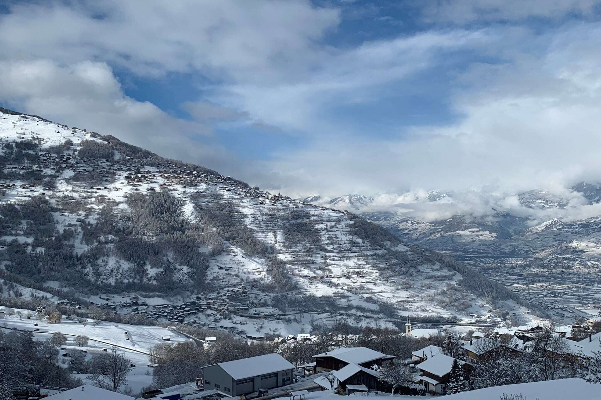 Een besneeuwd berglandschap met een dorpje aan de voet.