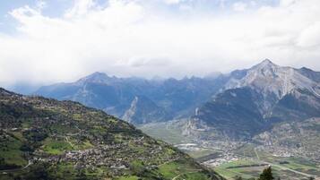 Un paisaje montañoso con un pueblo en el valle.