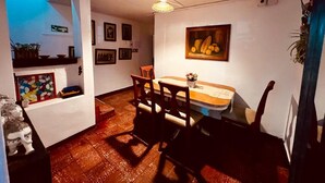 A dining area with a table, chairs, and a painting on the wall. - Balcon Plaza Villa de Leyva Hotel (Villa de Leyva)