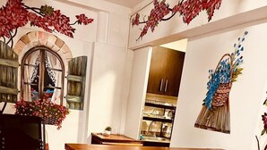 A cozy kitchen area with a wooden bar counter, a rustic archway, and a colorful striped rug. - Balcon Plaza Villa de Leyva Hotel (Villa de Leyva)