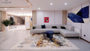 A modern hotel lobby with a reception desk, a sectional sofa, a coffee table, and a large abstract painting. - Landmark Hotel Erdenet (Erdenet)