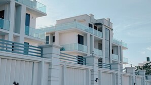 Un edificio a più piani con balconi e facciata bianca.