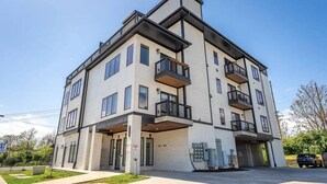 Een meerlaags woongebouw met balkons, een garage-ingang en een zichtbare meterkast.