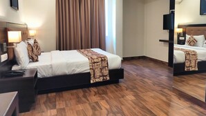 A hotel room with a bed, bedside tables, a lamp, a mirror, and a large window with curtains. - VITS SELECT BENGALURU (Bengaluru)