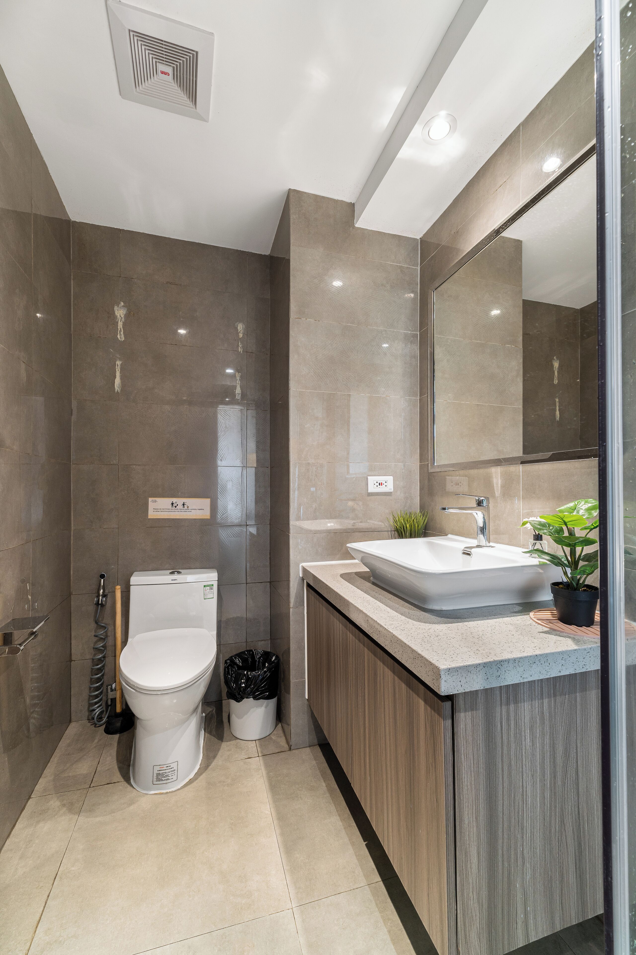 A modern bathroom with a toilet, sink, and mirror.