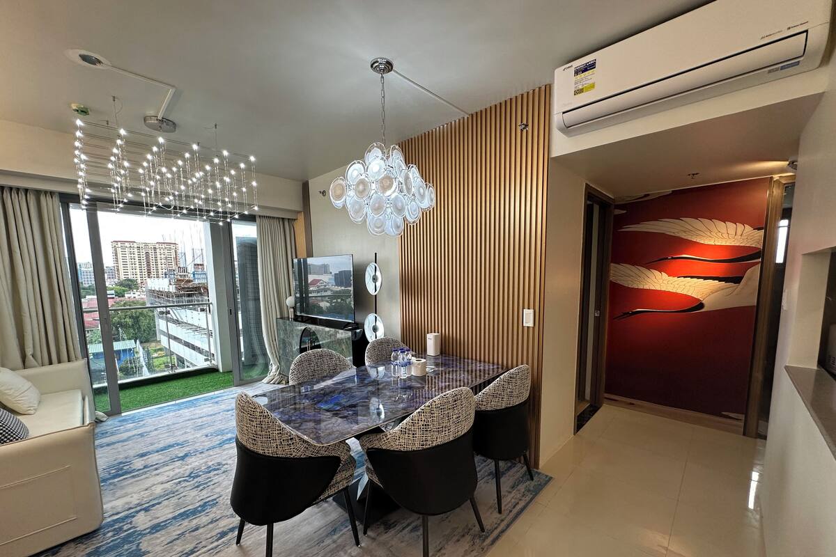 Ein modernes Wohnzimmer mit Essbereich, großen Fenstern und Blick auf die Stadt.