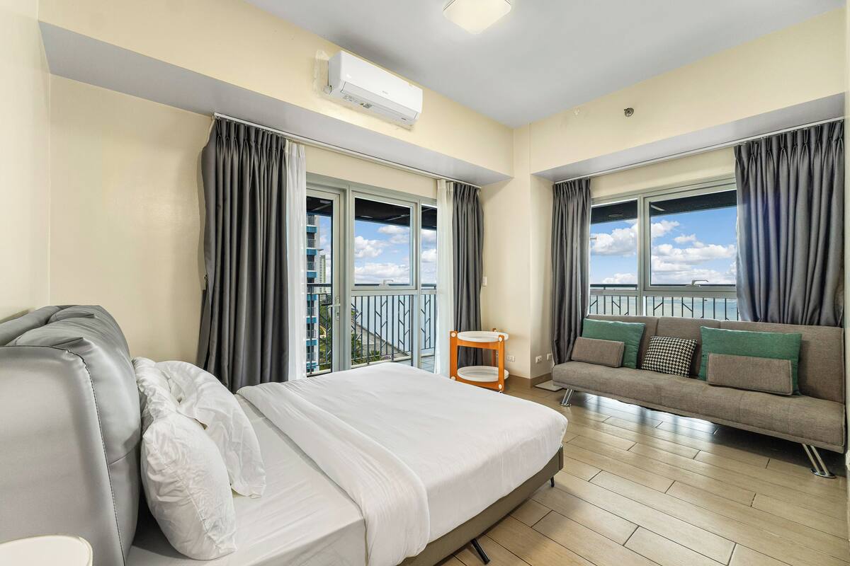 Ein Hotelzimmer mit Bett, einer Sitzecke, einem kleinen Tisch und einem Balkon mit Aussicht.