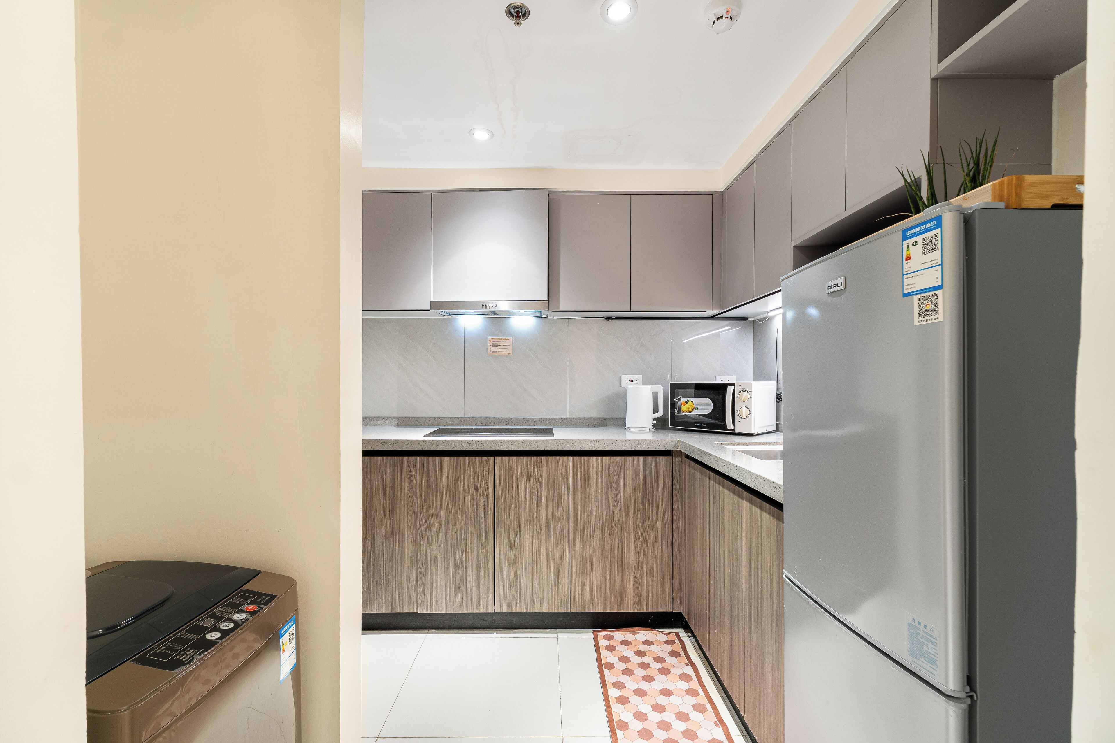 Cocina compacta con refrigerador, microondas y lavadora.