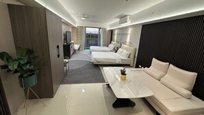 A modern hotel room with a sofa, a bed, a TV, and a potted plant. - Spacious & High-Floor Hotel near City of Dreams, Airport, Okada, and Solaire Casino (Parañaque)